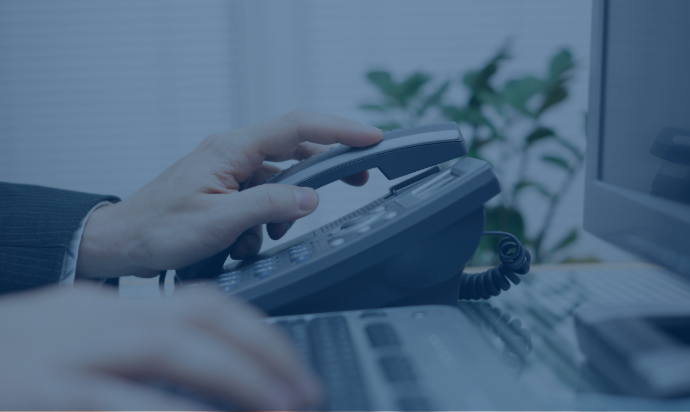 hand over an Ip Phone next to a computer